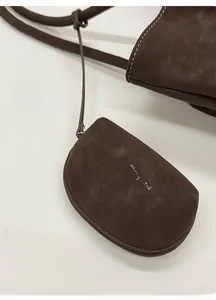 Close-up of a dark brown leather headphone pouch with matte texture and white logo