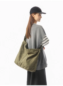 Détail du sac bandoulière en toile lavée vert olive avec une large bandoulière réglable