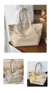 Dettaglio di una grande borsa tote crema con trama in pelle naturale e fibbie dorate