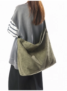 Détail d'un grand sac hobo vert armée en suédine douce porté par un mannequin