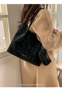 Close-up of black matte suede tote bag with matching pouch and white fashion logo