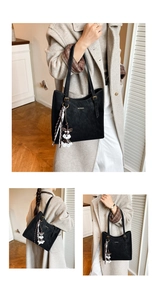 Close-up of black retro tote bag with golden logo, silk scarf and puppy charm details
