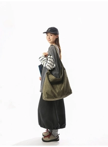 Détail d'un grand sac bandoulière en toile vert olive avec effet drapé et capacité spacieuse