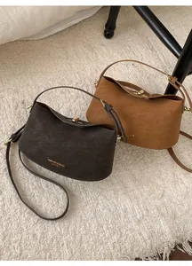 Détails de sacs style dumpling en cuir avec bandoulières réglables et fermoirs métalliques