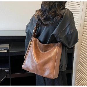 Detail showing vintage brown leather tote bag with side zipper and stitched craftsmanship