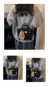 Detail of black crossbody bag with brown plush bear charm and golden metal hardware