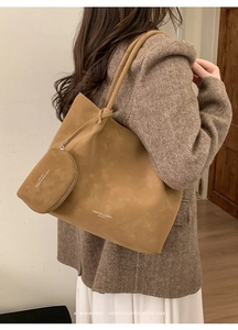 Detail of camel suede tote bag and matching mini pouch worn with a retro blazer