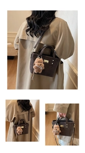 Detailed view of brown matte bucket bag with a cute plush dog charm and long shoulder strap