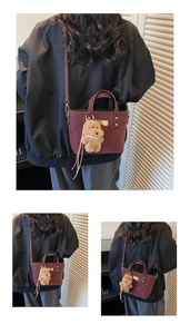 Detail of wine red mini tote bag featuring a cute plush dog charm and pearl necklace