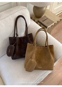 Macro detail of suede leather tote bag set featuring embossed fashion logo and smooth texture