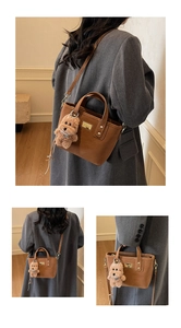 Brown leather handbag with gold plaque and cute plush teddy bear charm detail