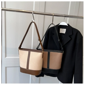 Detail of a medium bucket bag featuring a color-block design and textured matte finish