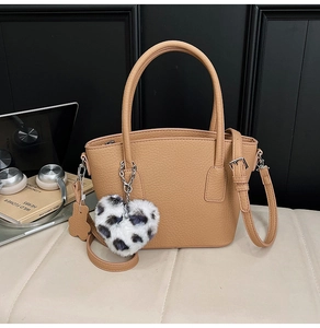 Detail view of khaki faux leather shoulder bag with plush leopard heart and flower charms