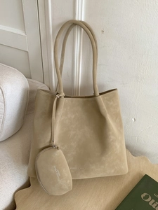 Beige suede tote bag with long straps and matching mini pouch on a minimalist background