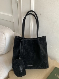 Black matte leather tote bag with white contrast stitching and a matching coin purse