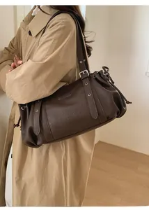 Detailed side view of a large dark brown leather tote bag with an adjustable strap