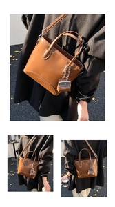 Close-up of a vintage brown glossy tote bag with a mini lipstick charm and metal chain