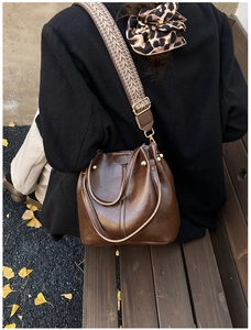 Sac seau vintage marron avec sangle tissée et boucle en métal doré en vue extérieure