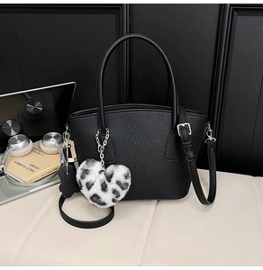 Detail of black lychee grain bag with leopard heart charm and silver metal hardware