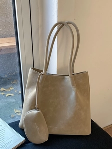 Minimalist beige matte leather tote bag with small matching pouch and shoulder straps