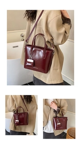 Detail of burgundy glossy tote bag set with mini charm and adjustable thin shoulder strap