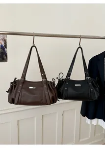 Detail of minimalist tote bags with drawstring sides and silver buckle in brown and black