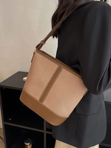 Fashionable beige canvas and brown leather bucket bag with shoulder strap for women