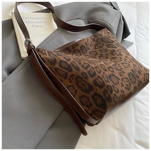Detail of leopard print shoulder bag featuring side buckle and brown leather strap
