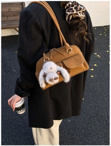 Brown suede bowling bag with dual front pockets and a cute plush rabbit charm detail