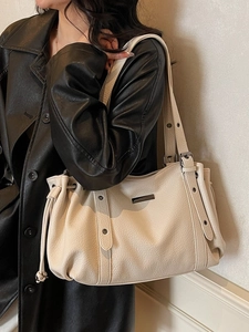 Chic beige pebbled leather tote bag with drawstring side details for winter 2025 fashion
