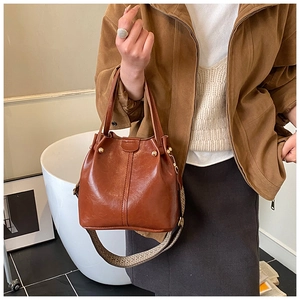 Détails du sac seau marron vintage en cuir brillant avec bandoulière ethnique tissée