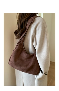 Detail of adjustable strap with silver buckle on brown suede hobo tote bag