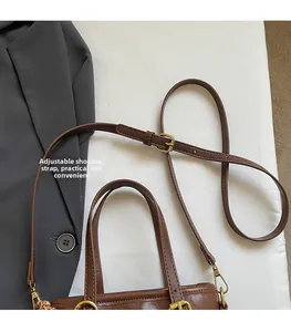Detail view of brown PU bucket bag showing adjustable shoulder strap and gold hardware