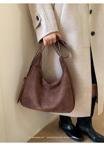 Brown faux suede hobo bag with wide shoulder strap styled with a wool coat