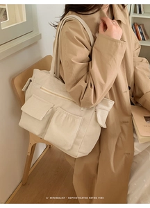 Close-up of beige corduroy tote bag featuring dual front flap pockets and retro texture
