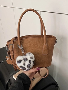 Vintage brown pebble leather hobo bag with a leopard heart charm and shoulder strap