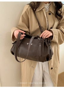 Detailed view of dark brown pebbled leather texture and silver hardware on shoulder bag