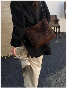 Close-up of leopard print shoulder bag with brown leather base on a model in autumn