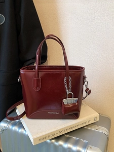 Retro burgundy patent leather bucket bag with shiny finish and mini pouch charm