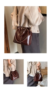 Detail einer dunkelbraunen Retro-Beuteltasche mit breitem Gurt am Model in Vintage-Optik