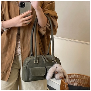Retro dark green bowling bag detail with front pockets and plush rabbit pendant charm