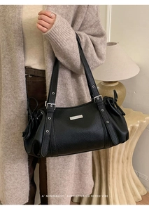 Minimalist black pebble leather shoulder bag with silver hardware and adjustable strap