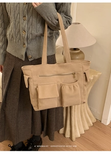 Close-up of beige corduroy tote bag showing multiple pockets and retro texture
