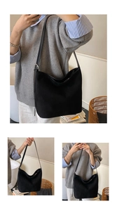Detail of minimalist black matte shoulder bag featuring metallic strap adjustment buckle