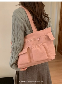 Detail of pink corduroy tote bag showing multiple pockets and retro texture on shoulder