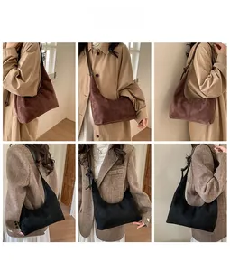 Detail view of suede crescent shoulder bags in brown and black with adjustable straps