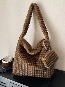 Brown faux fur tote bag with quilted texture and matching pouch in a lifestyle setting