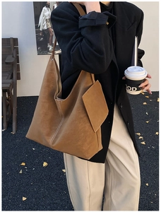 Sac cabas marron avec surpiqûres blanches porté par un mannequin en décor automnal