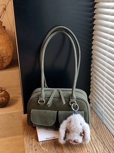 Vintage dark green suede bowling bag with dual front pockets and a plush bunny charm