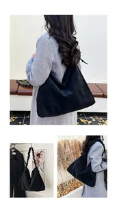 Detail of black tote bag featuring unique ruffled shoulder straps and bow knot accents